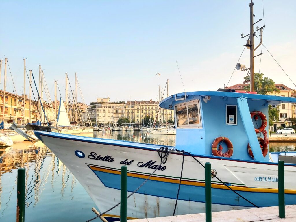 Un'immagine del porto turistico di Grado e di una imbarcazione di pescatori.